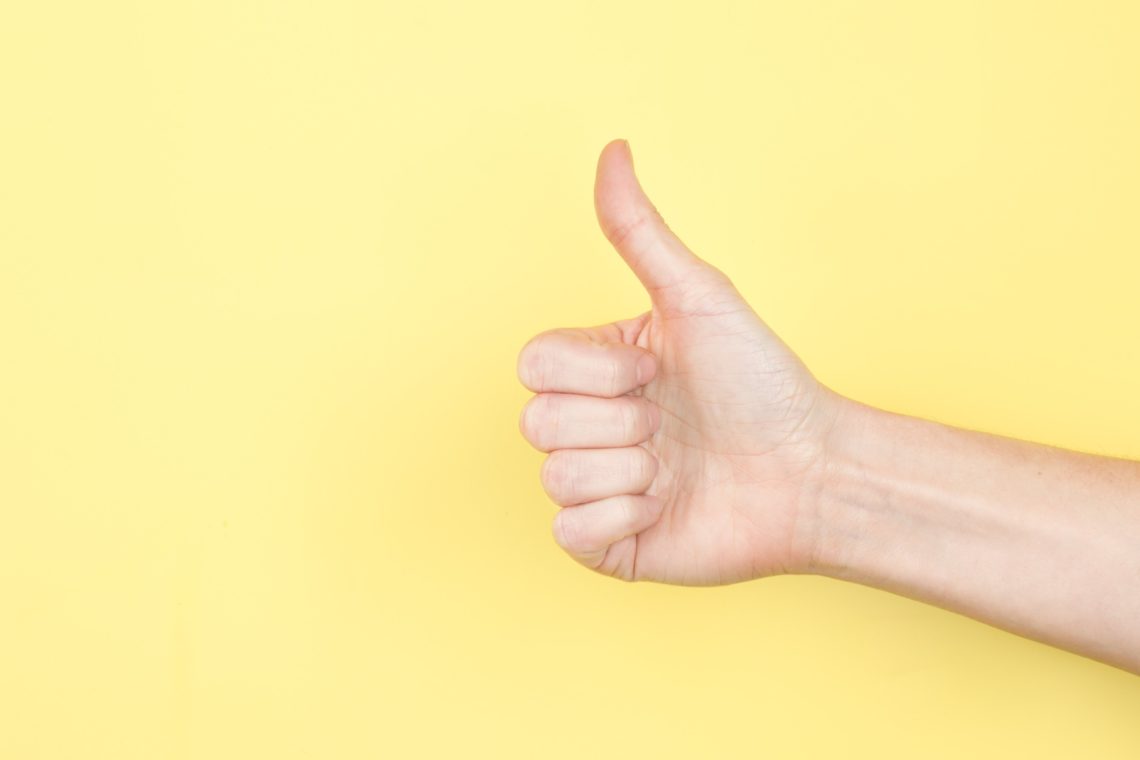 Thumbs up on yellow photo by Sarah Pflug