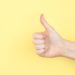Thumbs up on yellow photo by Sarah Pflug